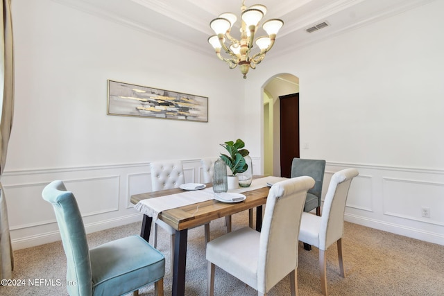 dining room with carpet flooring, a chandelier, and ornamental molding