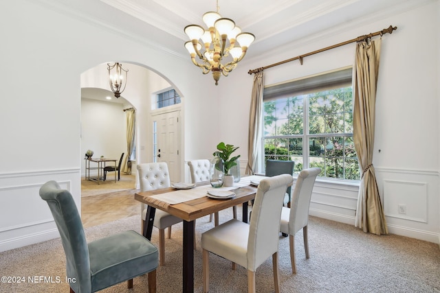 carpeted dining area with crown molding and a chandelier