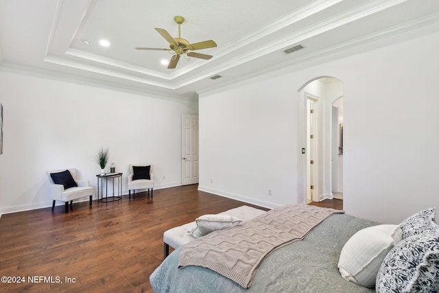 bedroom featuring ceiling fan, dark hardwood / wood-style floors, a raised ceiling, and crown molding