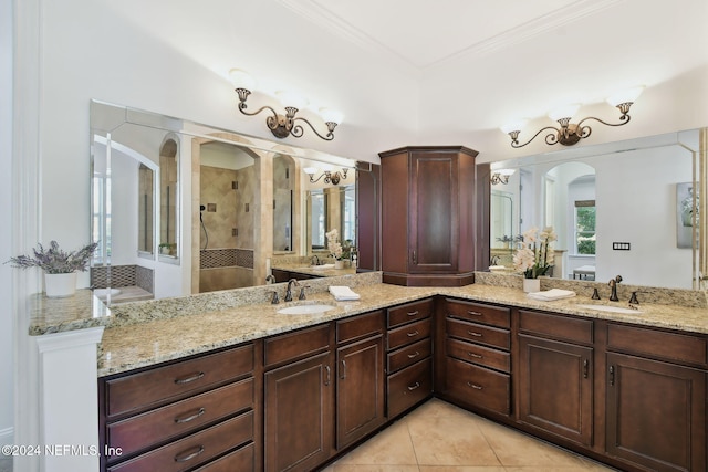 bathroom featuring tiled shower, vanity, tile patterned flooring, and crown molding