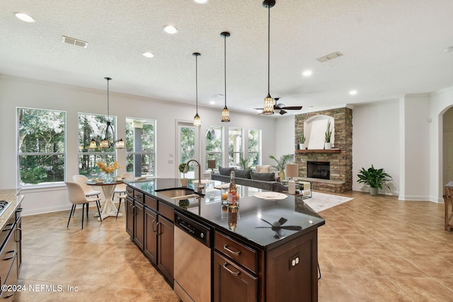 kitchen featuring a kitchen island with sink, sink, stainless steel dishwasher, and plenty of natural light