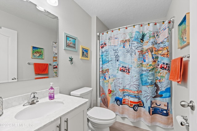 bathroom with a textured ceiling, vanity, walk in shower, toilet, and hardwood / wood-style flooring