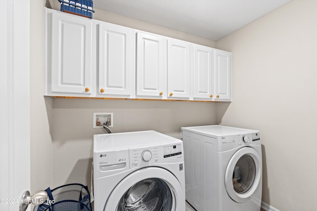 washroom featuring cabinets and washing machine and dryer