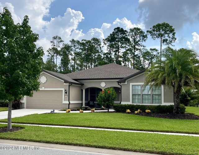 ranch-style house with a garage and a front lawn