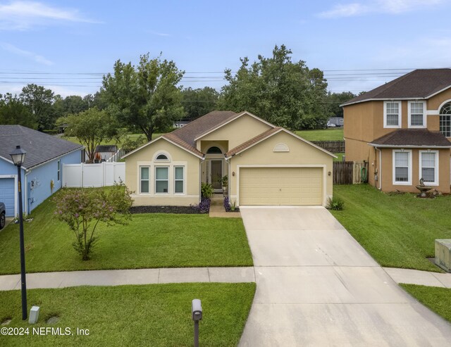 view of front of property featuring a front yard and a garage