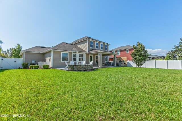 back of property featuring a patio and a lawn