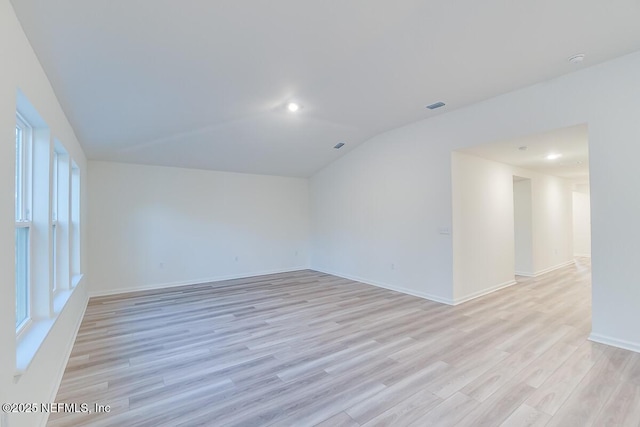 unfurnished room with lofted ceiling and light hardwood / wood-style flooring