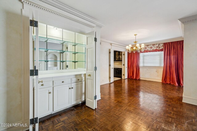 kitchen with dark parquet floors, white cabinetry, a chandelier, and crown molding