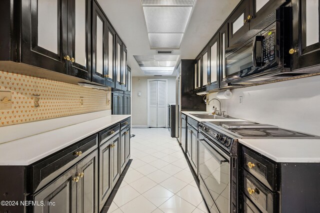 kitchen featuring black appliances, sink, and light tile patterned floors