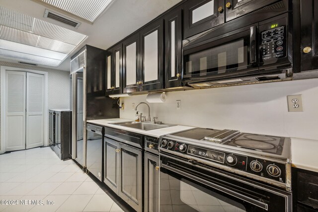 kitchen featuring black appliances, sink, and light tile patterned floors