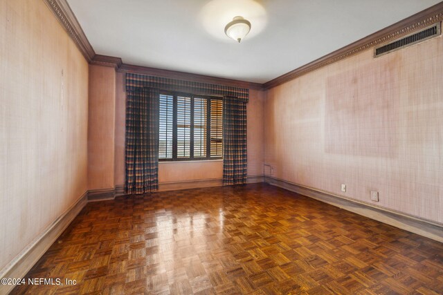 spare room with dark parquet flooring and crown molding