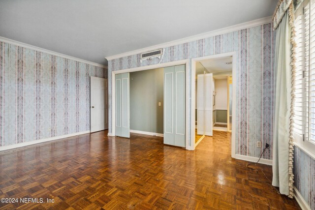 unfurnished bedroom with ornamental molding, a closet, and dark parquet floors