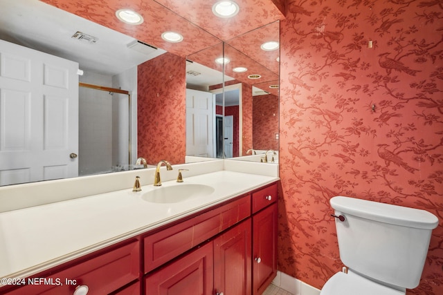 bathroom featuring vanity, toilet, and an enclosed shower