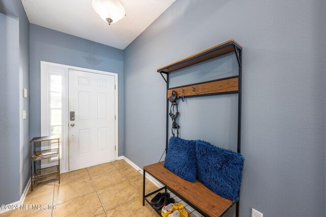 entryway featuring a textured ceiling and light tile patterned flooring