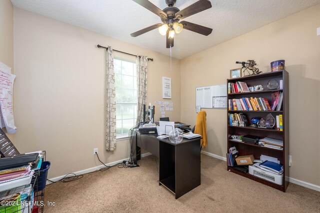 carpeted home office with ceiling fan and a textured ceiling