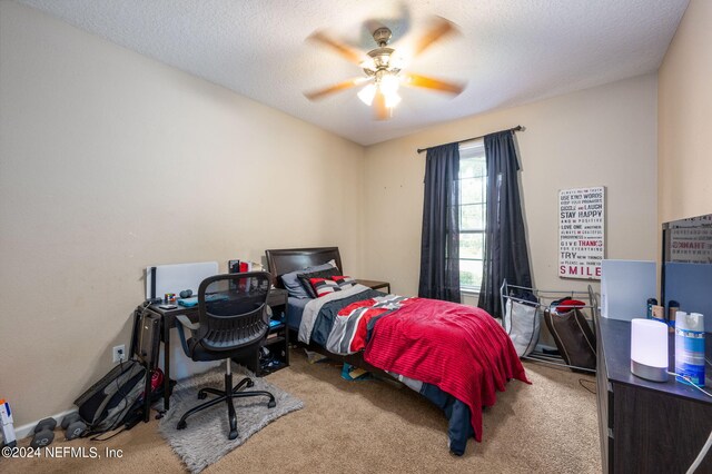 carpeted bedroom featuring a textured ceiling and ceiling fan