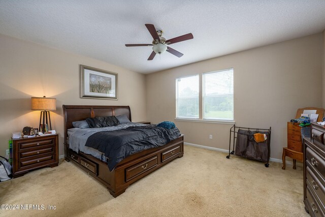 carpeted bedroom with a textured ceiling and ceiling fan