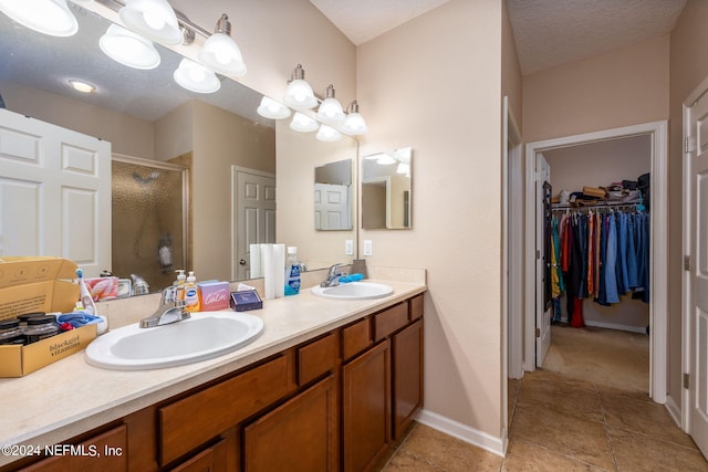 bathroom featuring walk in shower, a textured ceiling, and vanity