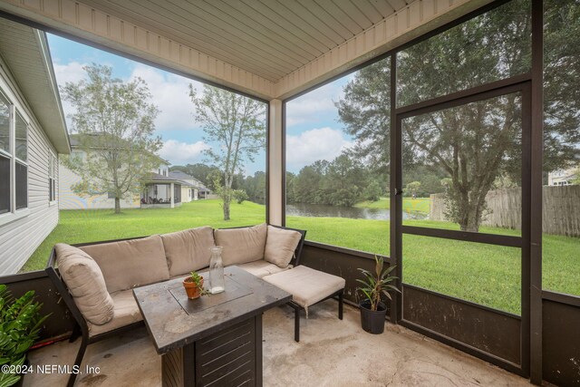 sunroom featuring plenty of natural light and a water view