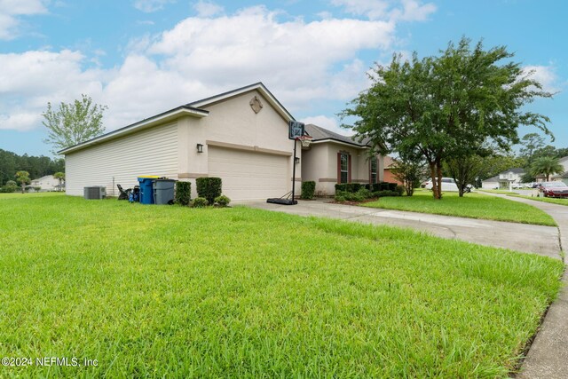 ranch-style house featuring a garage, a front lawn, and central air condition unit