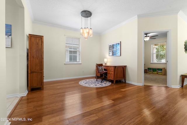 unfurnished room with ceiling fan with notable chandelier, a textured ceiling, hardwood / wood-style flooring, and crown molding