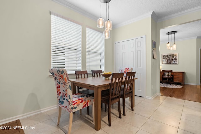 tiled dining space featuring ornamental molding and a textured ceiling