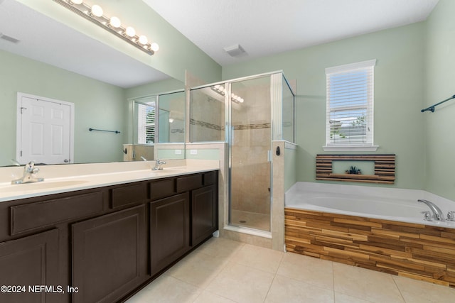 bathroom featuring plus walk in shower, vanity, tile patterned floors, and a healthy amount of sunlight