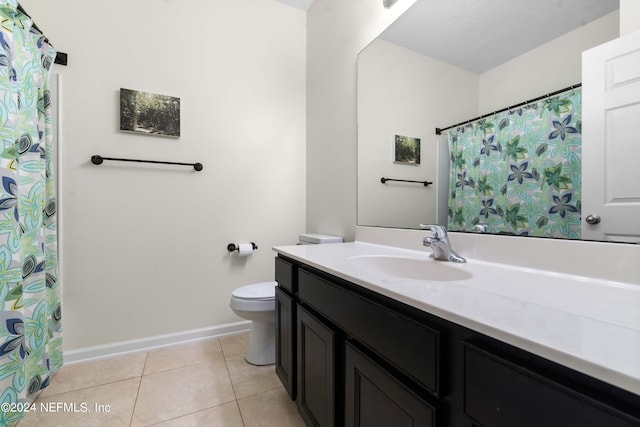 bathroom with tile patterned flooring, vanity, and toilet