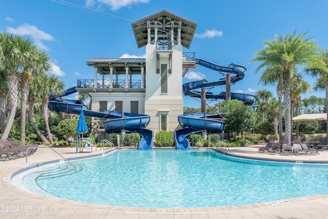 view of pool with a patio area and a water slide