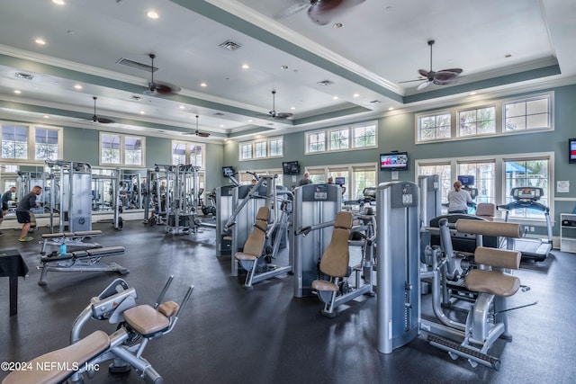 gym featuring ceiling fan, a raised ceiling, a towering ceiling, and crown molding