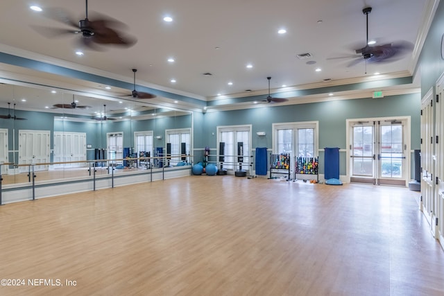 gym featuring french doors, light hardwood / wood-style floors, a high ceiling, and ornamental molding