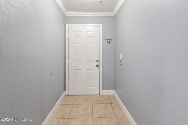 doorway with light tile patterned floors and ornamental molding