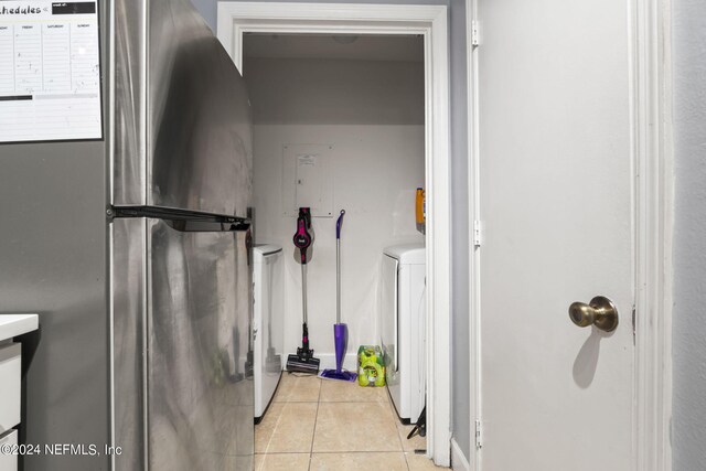 laundry area with washer / clothes dryer and light tile patterned floors