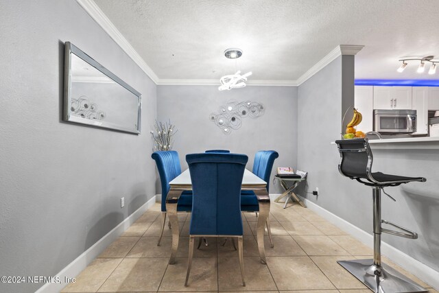 tiled dining space featuring crown molding, a textured ceiling, and a notable chandelier