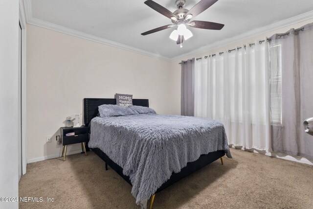 bedroom with ceiling fan, ornamental molding, carpet floors, and multiple windows