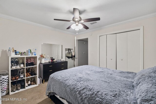 bedroom featuring carpet, ceiling fan, ornamental molding, and a closet