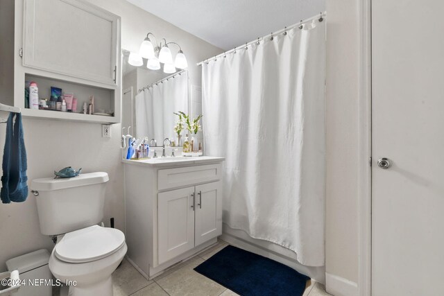 bathroom with vanity, toilet, curtained shower, and tile patterned floors