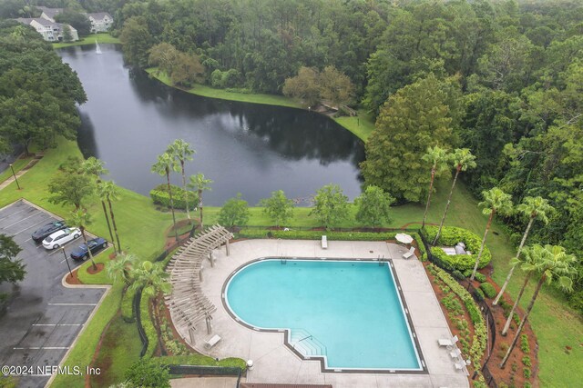 view of swimming pool with a water view and a yard