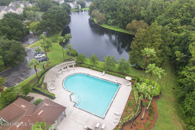 view of pool featuring a water view and a patio