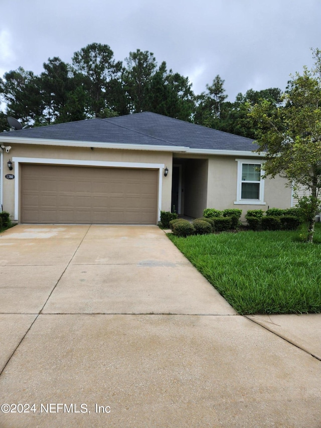 ranch-style house with a garage and a front yard