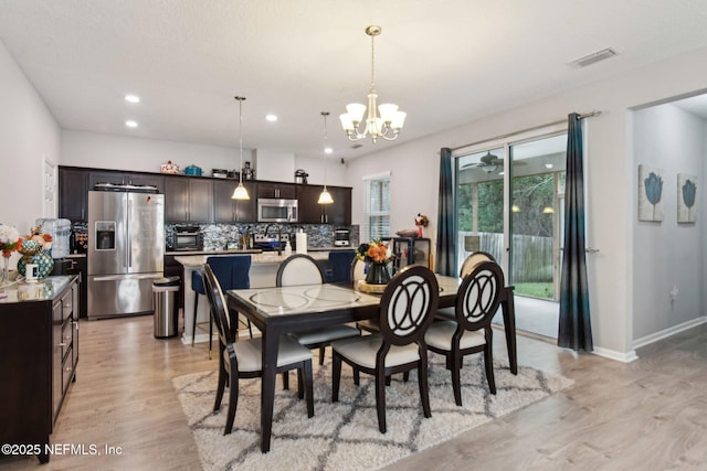 dining room featuring an inviting chandelier and light wood-type flooring