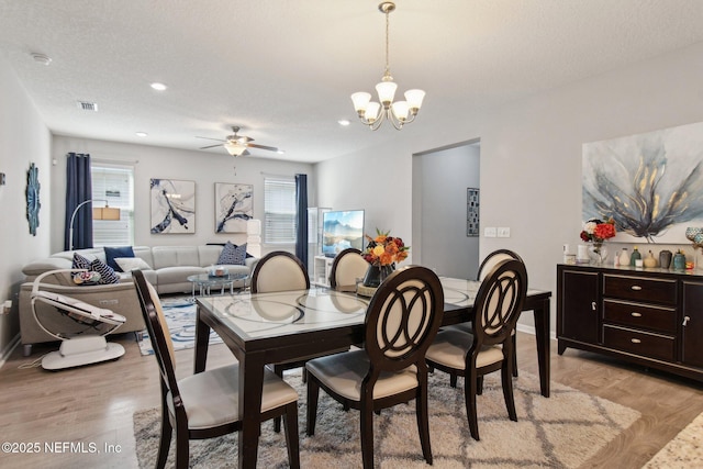 dining area with a healthy amount of sunlight, a textured ceiling, and light wood-type flooring