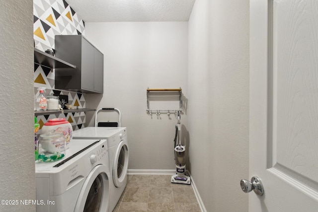 laundry area with washing machine and clothes dryer and a textured ceiling