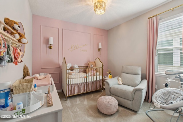 bedroom with a crib, carpet flooring, and multiple windows