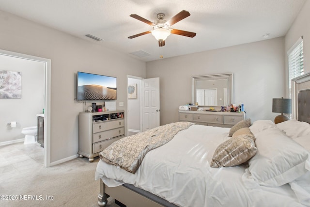 bedroom with light carpet, ceiling fan, and ensuite bath