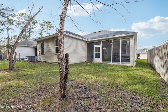 back of house with a sunroom, a yard, and cooling unit