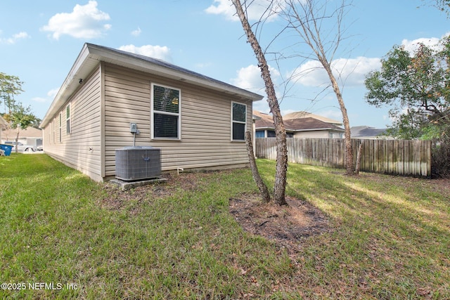 view of property exterior with a yard and central air condition unit