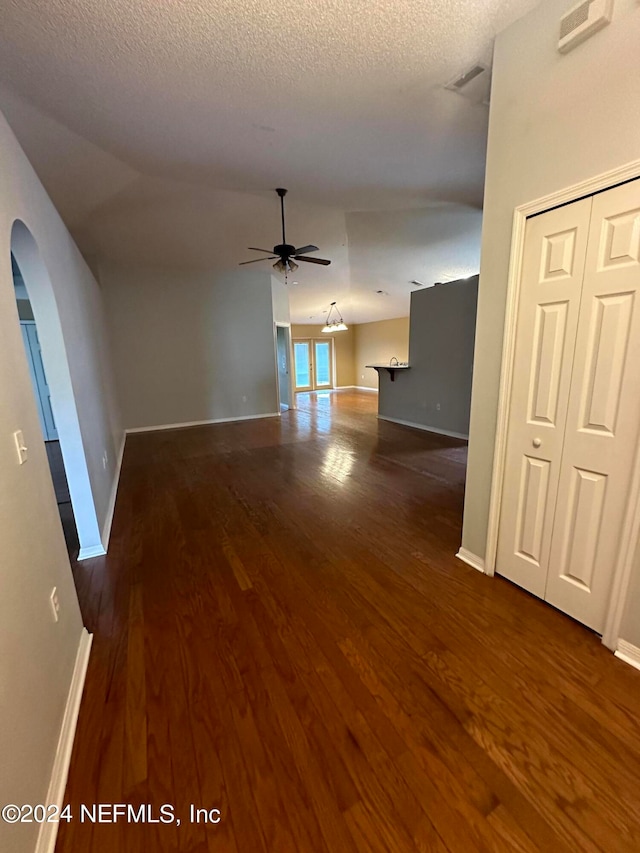 interior space featuring a textured ceiling, wood-type flooring, ceiling fan, and lofted ceiling