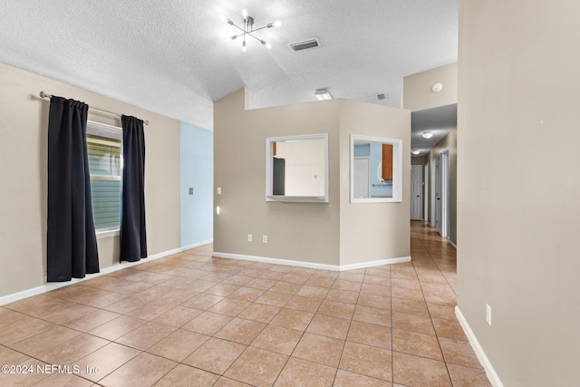 empty room featuring light tile patterned floors and a textured ceiling