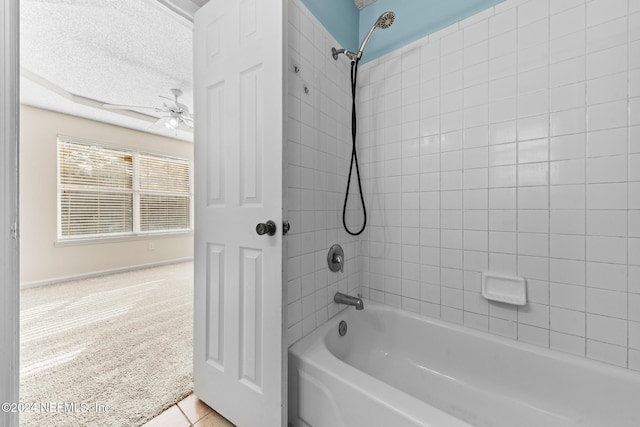 bathroom featuring ceiling fan, tiled shower / bath, and a textured ceiling